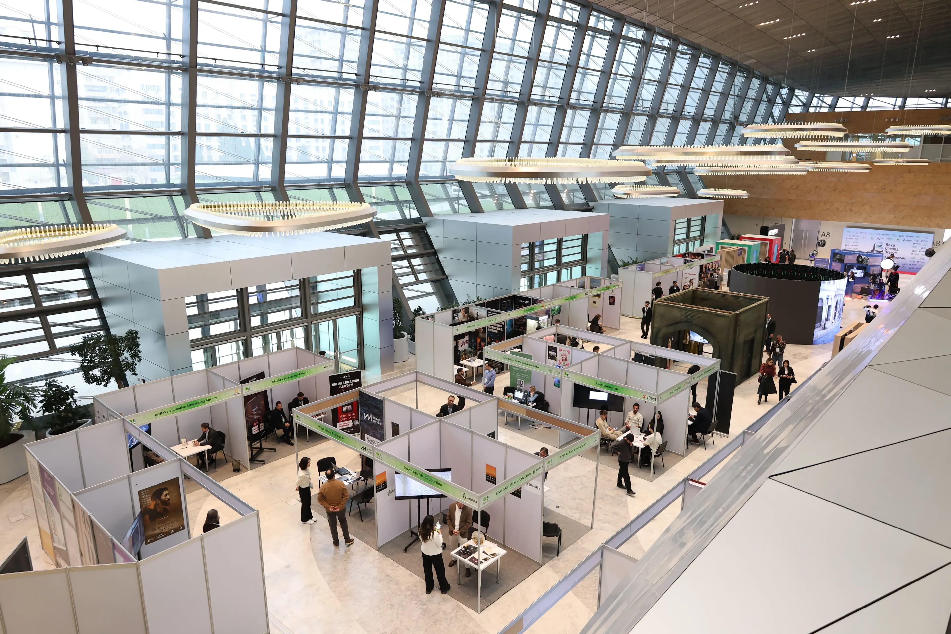 Vue en hauteur des stands et visiteurs d’un salon professionnel